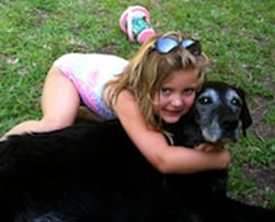 Animal Hospital in Newburry: Young girl playing with dog outside